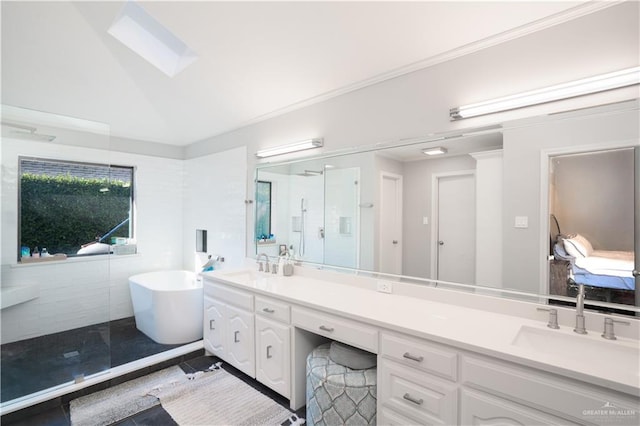 bathroom with tile patterned floors, vanity, separate shower and tub, and vaulted ceiling with skylight