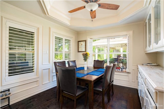 dining space with dark hardwood / wood-style floors, a tray ceiling, crown molding, and ceiling fan