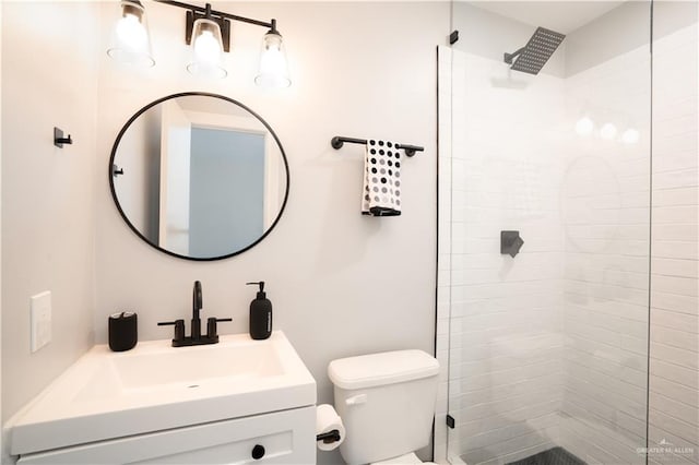 bathroom with vanity, toilet, and a tile shower