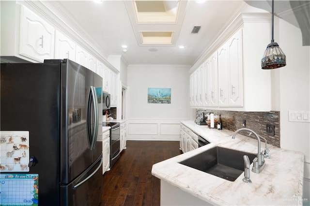 kitchen featuring white cabinetry, sink, tasteful backsplash, pendant lighting, and appliances with stainless steel finishes