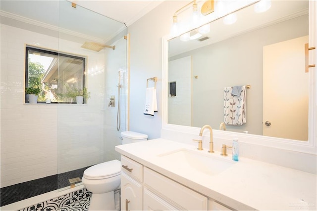 bathroom with tiled shower, crown molding, vanity, and toilet