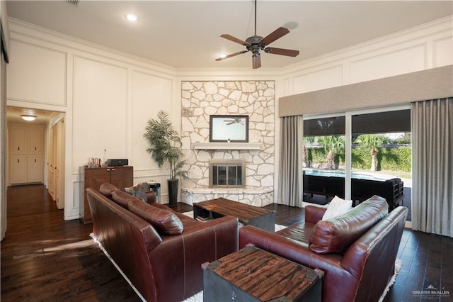 living room featuring a fireplace, ceiling fan, and dark wood-type flooring