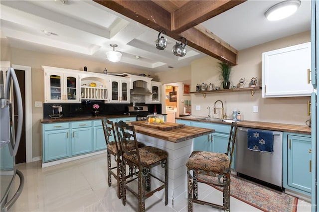 kitchen featuring stainless steel appliances, a kitchen breakfast bar, white cabinets, blue cabinets, and wood counters