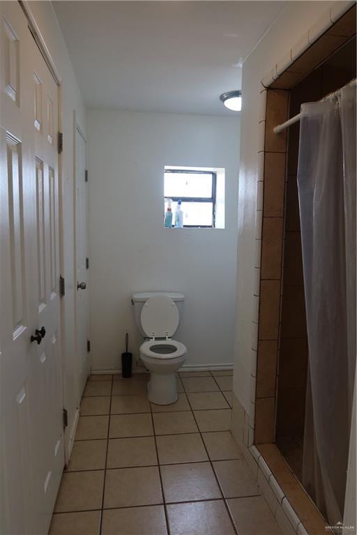 116 N Kansas Ave, Weslaco, TX 78596 - full bath with toilet, a stall shower, tile patterned floors, and baseboards