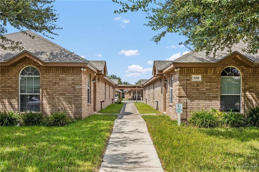 3709 W Faith Hill St, Edinburg, TX 78541 - view of property exterior with a lawn, brick siding, and roof with shingles