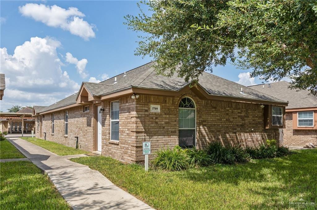 3709 W Faith Hill St, Edinburg, TX 78541 - view of property exterior with a lawn and brick siding