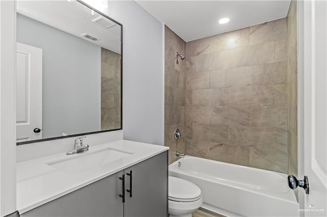 full bathroom with tiled shower / bath combo, toilet, and vanity