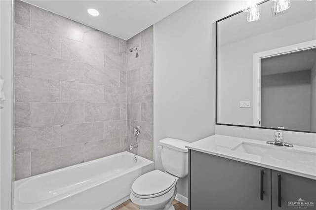 full bathroom with vanity, tiled shower / bath, and toilet