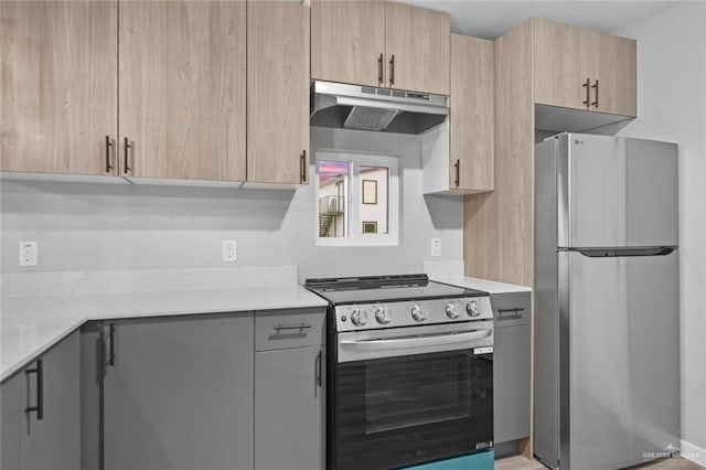 kitchen featuring stainless steel fridge, light brown cabinets, and electric range oven