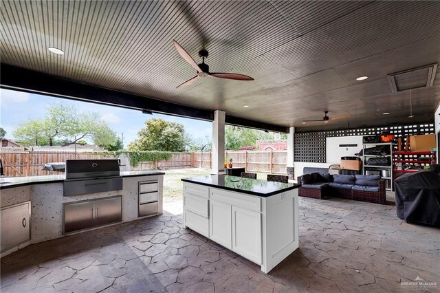 308 N Holland Ave, Mission, TX 78572 - fenced backyard featuring exterior kitchen, a patio area, ceiling fan, and an outdoor living space