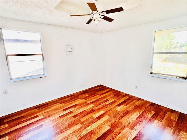 spare room with hardwood / wood-style flooring, ceiling fan, and a textured ceiling