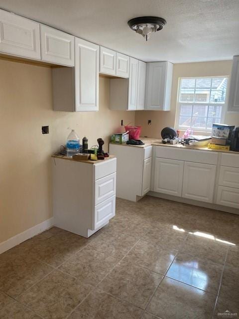 kitchen with white cabinets and light tile patterned floors