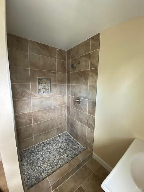 bathroom featuring tile patterned floors, sink, and tiled shower