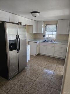 kitchen with white cabinets, stainless steel fridge, and sink