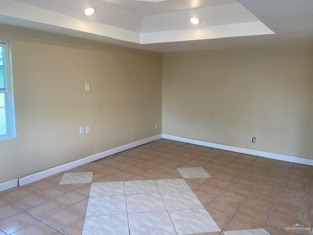 tiled empty room with a tray ceiling