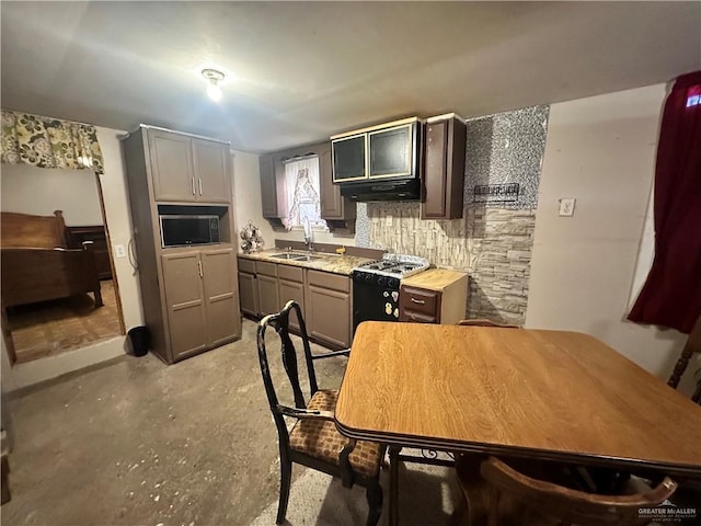 kitchen with range with gas stovetop, light countertops, gray cabinetry, a sink, and under cabinet range hood