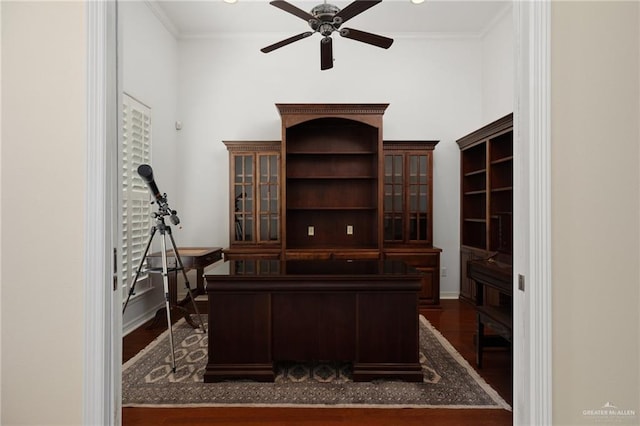 office area with dark wood-type flooring, a ceiling fan, baseboards, and ornamental molding
