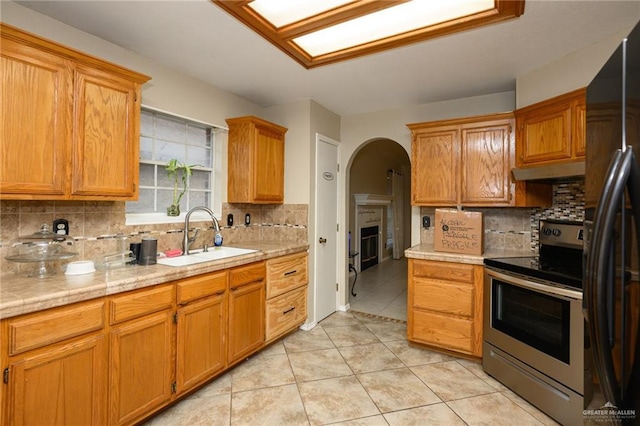 1905 N 8th St, Harlingen, TX 78550 - kitchen with electric stove, a sink, arched walkways, and backsplash