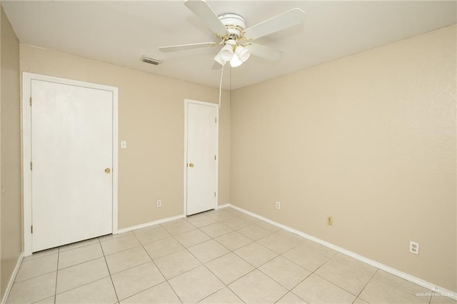 1905 N 8th St, Harlingen, TX 78550 - unfurnished bedroom with light tile patterned flooring, baseboards, and a ceiling fan
