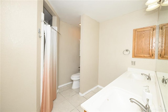 1905 N 8th St, Harlingen, TX 78550 - bathroom with toilet, tile patterned flooring, double vanity, baseboards, and curtained shower