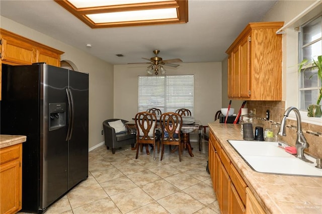 1905 N 8th St, Harlingen, TX 78550 - kitchen with black refrigerator with ice dispenser, tile countertops, a sink, tasteful backsplash, and ceiling fan