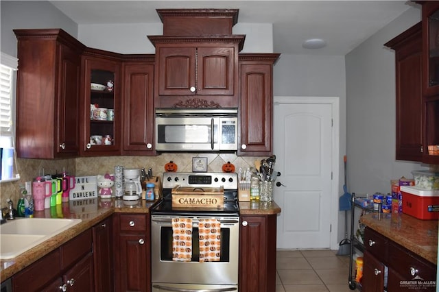 kitchen featuring light stone countertops, sink, stainless steel appliances, backsplash, and light tile patterned flooring