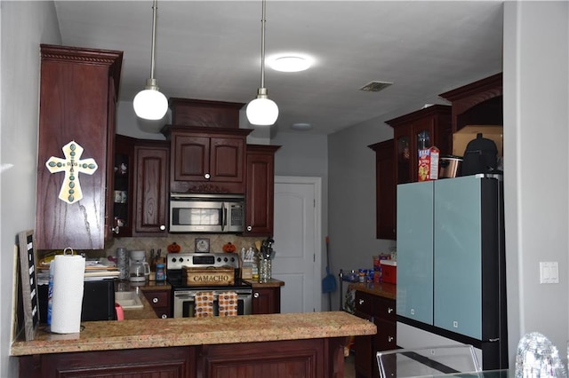 kitchen with stainless steel appliances, tasteful backsplash, kitchen peninsula, decorative light fixtures, and dark brown cabinets