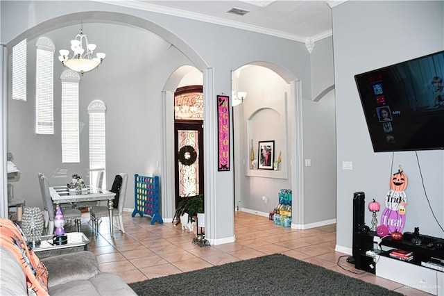 tiled foyer with crown molding and a notable chandelier