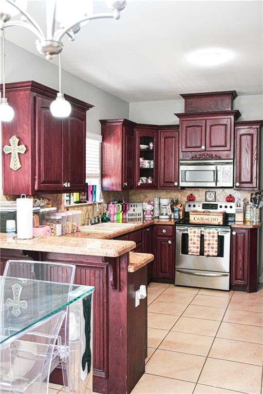 kitchen with sink, stainless steel appliances, tasteful backsplash, pendant lighting, and a kitchen bar