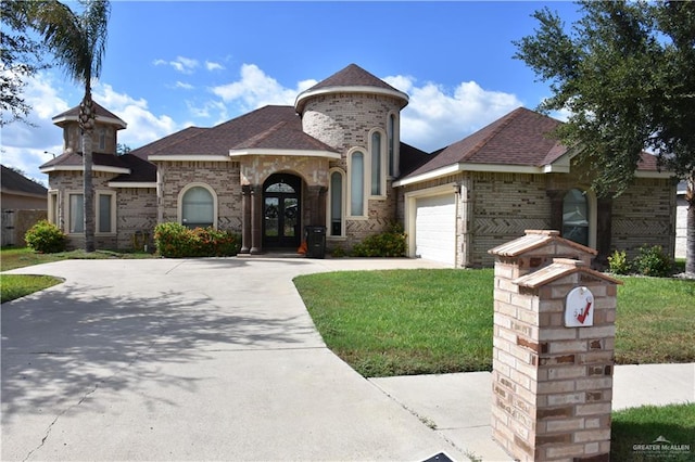 view of front of home featuring french doors, a front yard, and a garage