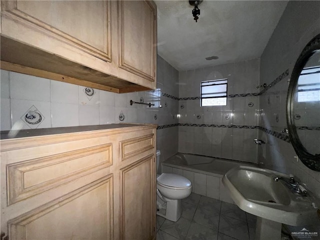 bathroom featuring sink, tile patterned flooring, a bath, backsplash, and toilet