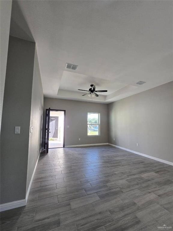 1204 Cornerstone Loop, Rio Grande City, TX 78582 - empty room with ceiling fan, a raised ceiling, baseboards, and visible vents