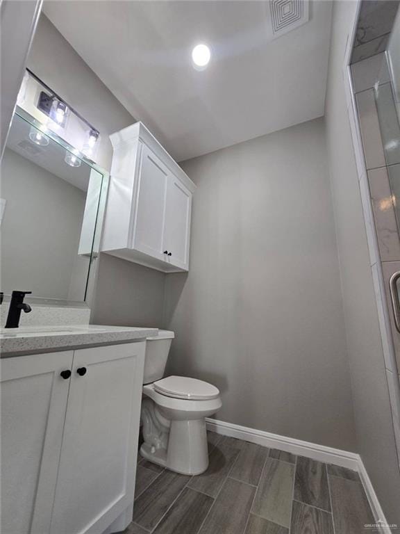 1204 Cornerstone Loop, Rio Grande City, TX 78582 - bathroom featuring toilet, vanity, visible vents, wood tiled floor, and baseboards