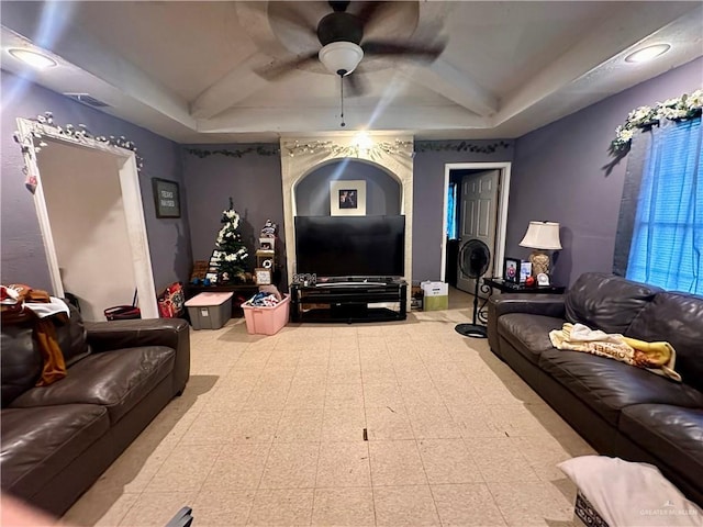 living room featuring a tray ceiling and ceiling fan