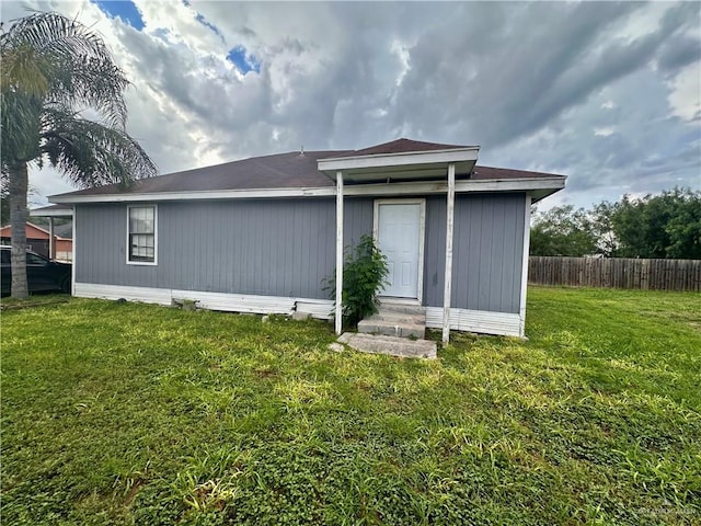 rear view of property featuring a yard