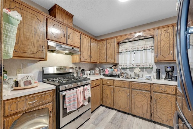 2310 Kim Marie Ave, Mission, TX 78574 - kitchen featuring stainless steel range with gas cooktop, under cabinet range hood, light countertops, and light wood-style flooring