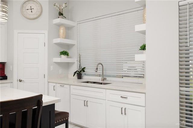 kitchen featuring white cabinetry, sink, and pendant lighting