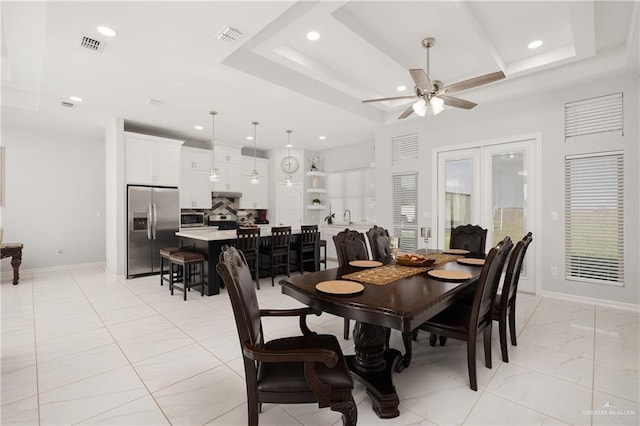 dining space with a raised ceiling and ceiling fan