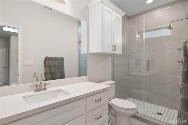 bathroom with vanity, toilet, and a shower with shower door