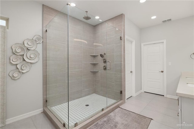 bathroom featuring tile patterned flooring, vanity, and a shower with door