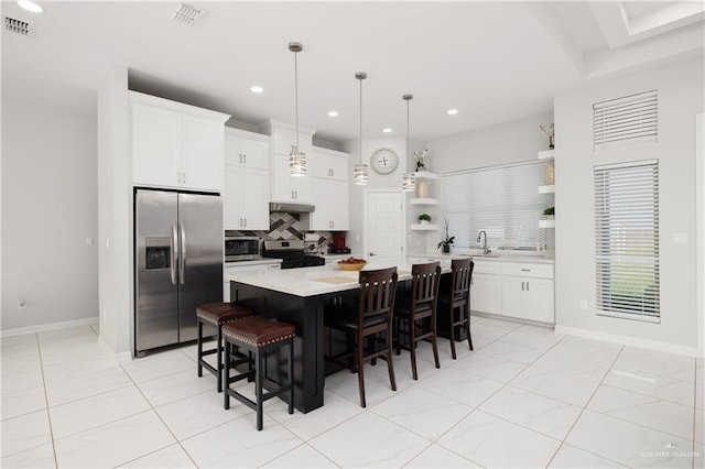 kitchen with white cabinetry, a center island, stainless steel appliances, pendant lighting, and a breakfast bar area