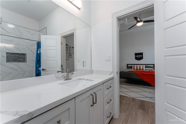 bathroom featuring hardwood / wood-style flooring, vanity, ceiling fan, and walk in shower