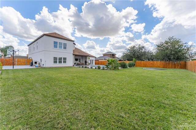 rear view of property featuring a yard and a patio