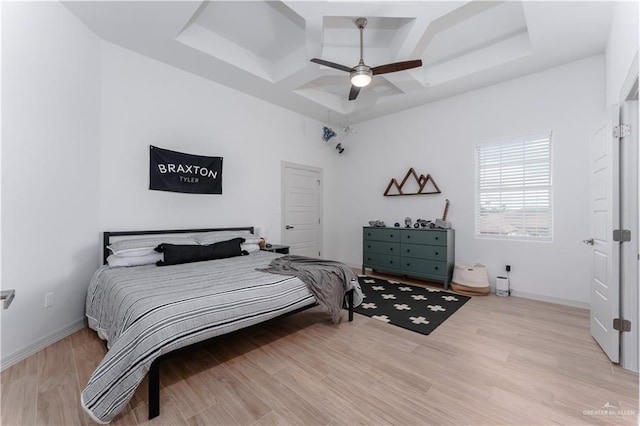 bedroom featuring light hardwood / wood-style flooring, ceiling fan, and a high ceiling