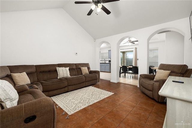 tiled living room featuring ceiling fan and high vaulted ceiling