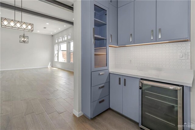 202 Constellation Dr E, Pharr, TX 78577 - kitchen featuring beverage cooler, tasteful backsplash, wood finished floors, hanging light fixtures, and open floor plan
