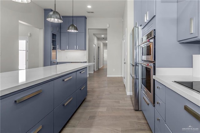 202 Constellation Dr E, Pharr, TX 78577 - kitchen with blue cabinets, stainless steel appliances, light countertops, decorative backsplash, and recessed lighting