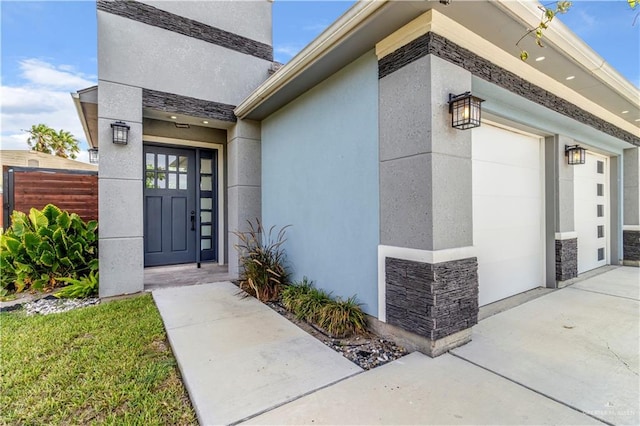202 Constellation Dr E, Pharr, TX 78577 - doorway to property with stone siding, stucco siding, concrete driveway, and a garage
