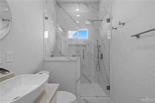 bathroom with a shower with shower door, toilet, and vanity