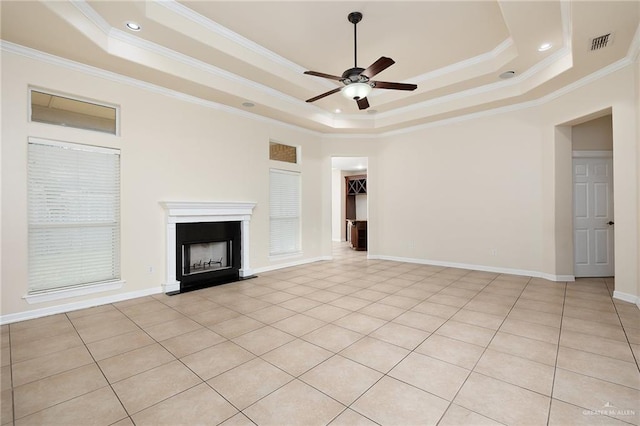 unfurnished living room featuring a raised ceiling, ceiling fan, light tile patterned floors, and ornamental molding